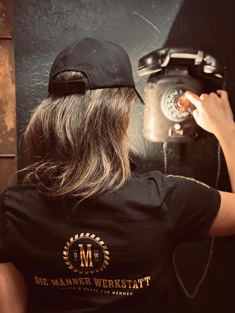Mitarbeiterin der Männer Werkstatt am Retro-Telefon