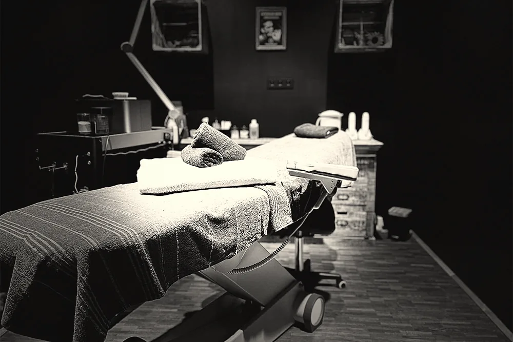 Behandlungsliege im abgedunkelten Raum der Männer Werkstatt für Rücken- und Brust-Waxing