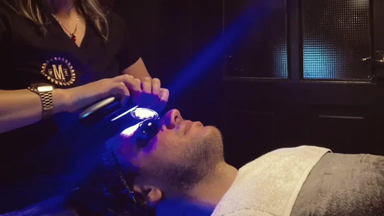 Valentine's Day gift for him: facial with LED light, beautician holding the light device over a man's face