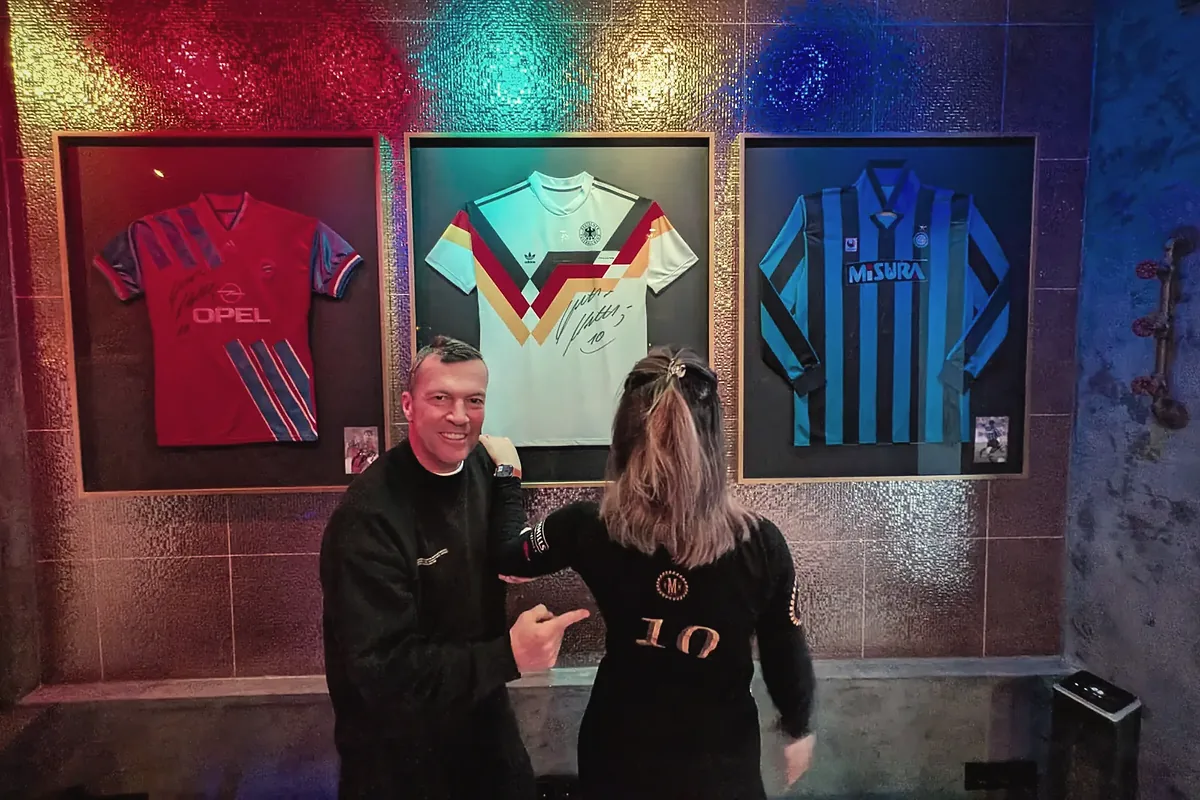 Private Spa „10 the Lodge“: Gast und Mitarbeiterin vor der Wand mit drei gerahmten Fußballtrikots